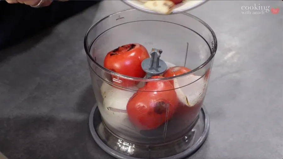 Charred tomatoes, onions, and garlic in a food processor with soaked dried chillies before blending into salsa roja.
