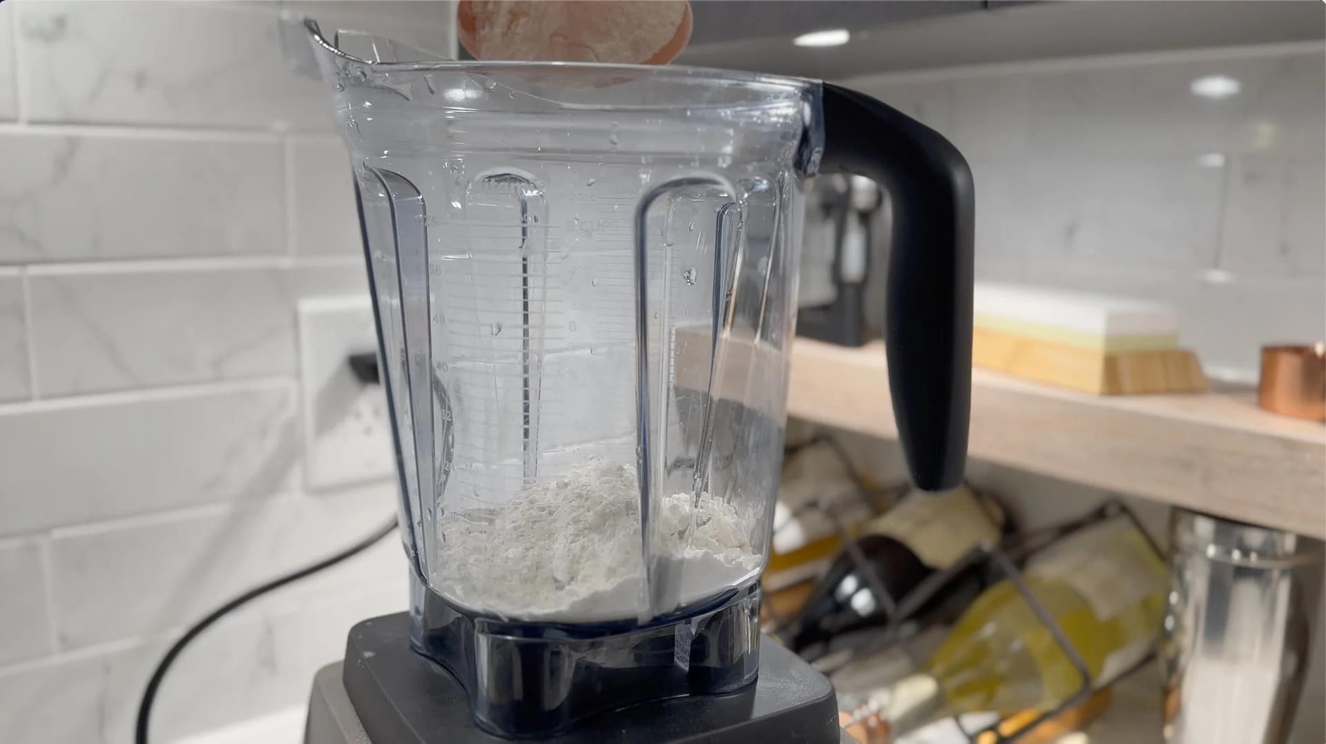 Blender pitcher filled with dry gluten-free chocolate crepe batter ingredients before mixing.