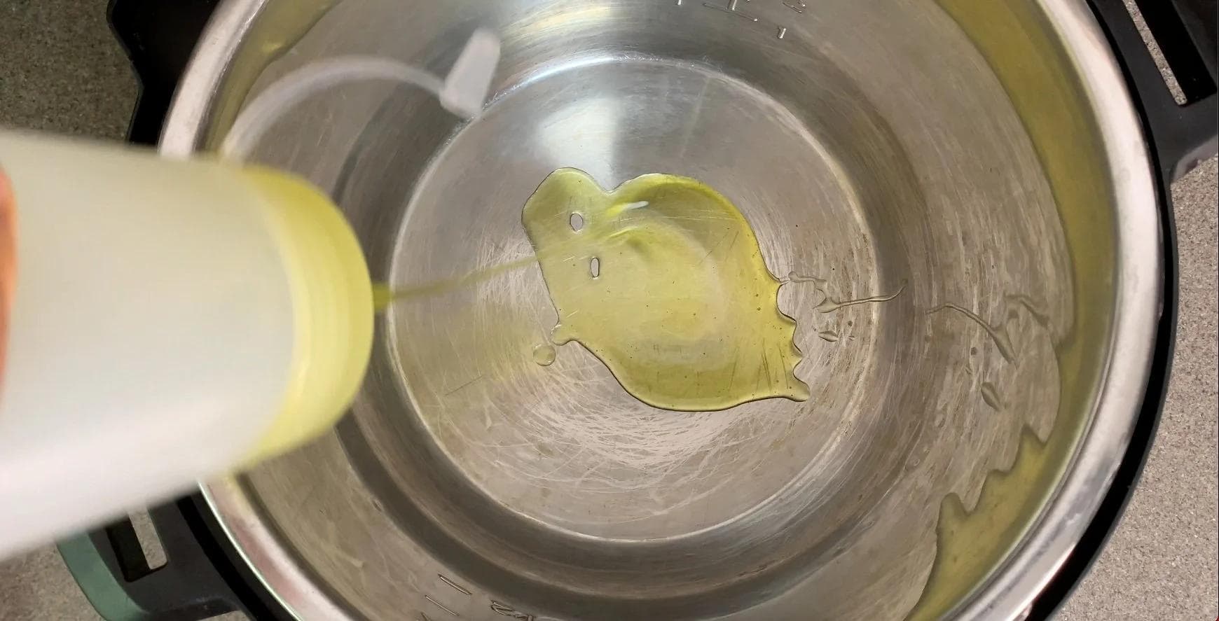 Olive oil and diced jalapeño pepper in stainless steel Instant Pot on sauté mode