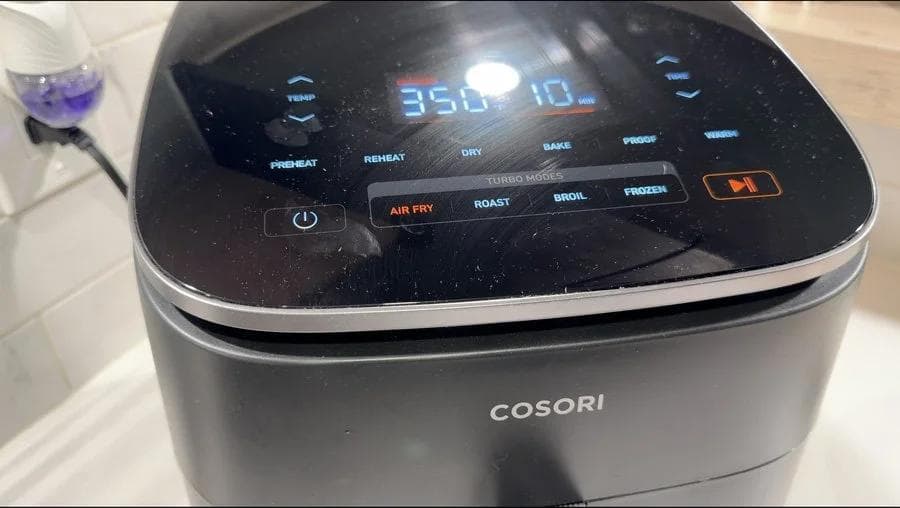 Cosori air fryer displaying 350°F temperature on digital screen with cooking mode buttons visible.