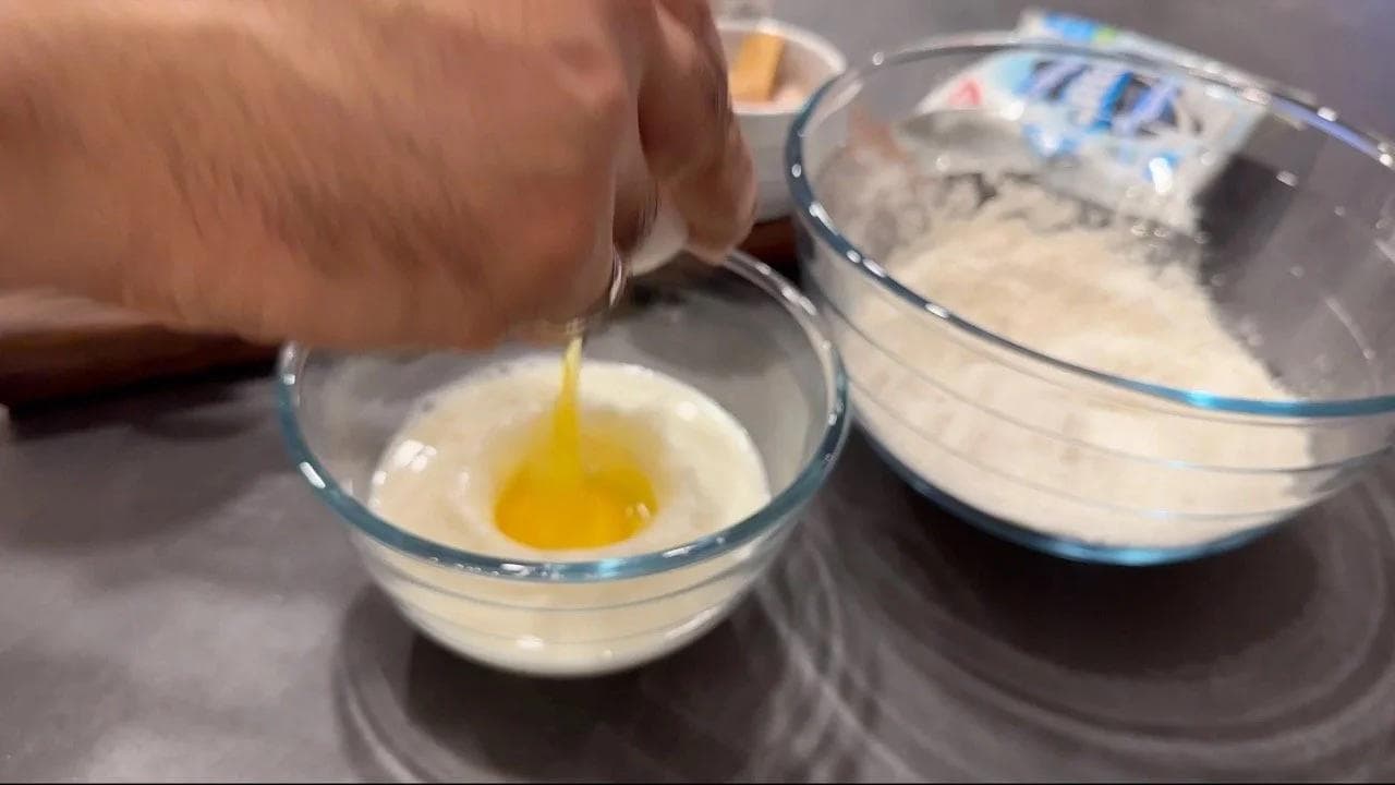 Pouring melted butter into a bowl of wet pancake batter ingredients beside a bowl of dry ingredients.