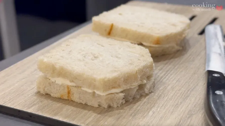 Two assembled mozzarella in carrozza sandwiches with crusts trimmed, ready for egg dipping.