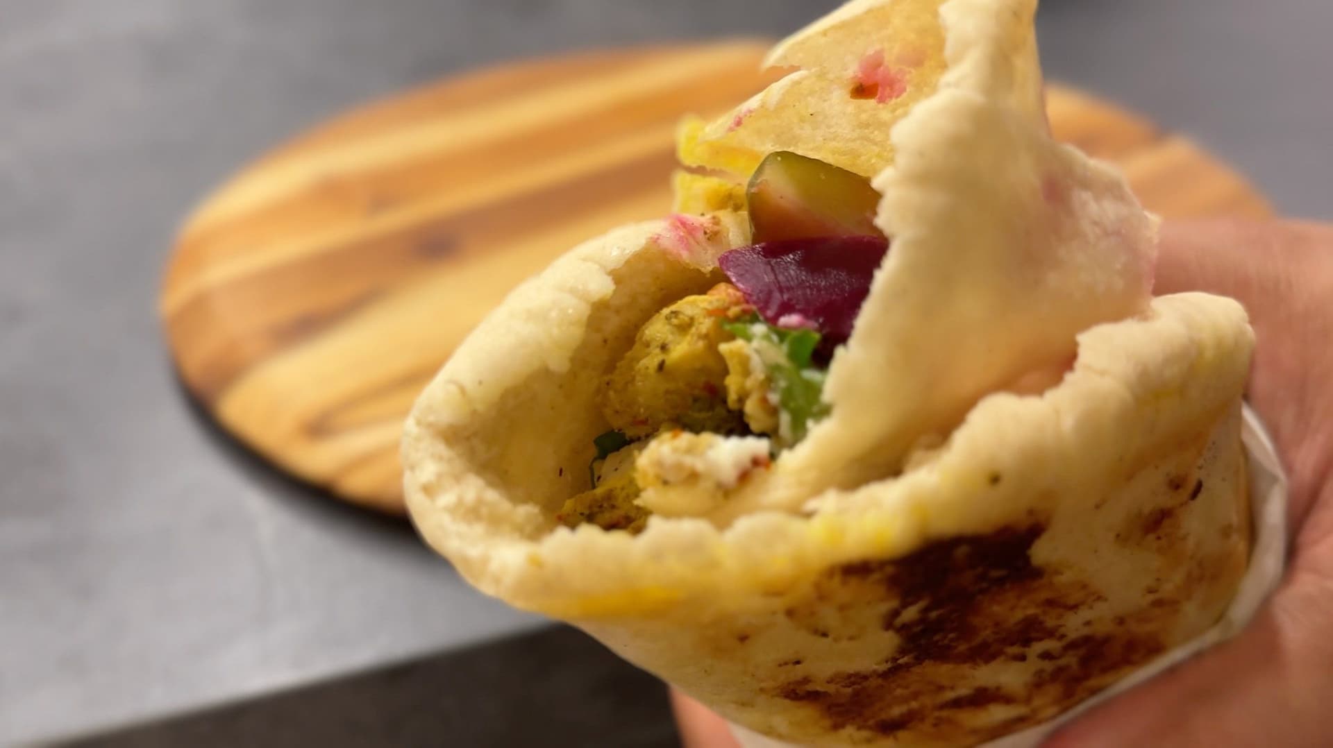 Homemade chicken shawarma wrapped in parchment paper, filled with seasoned chicken, vegetables, and sauce.